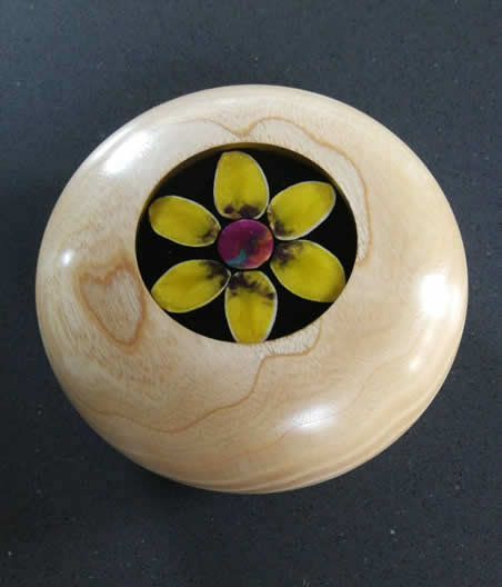 Beech-wood paperweight, with flower made from pistachio nuts filled with coloured resin, with clear resin turned and polished, by Tony Seeney